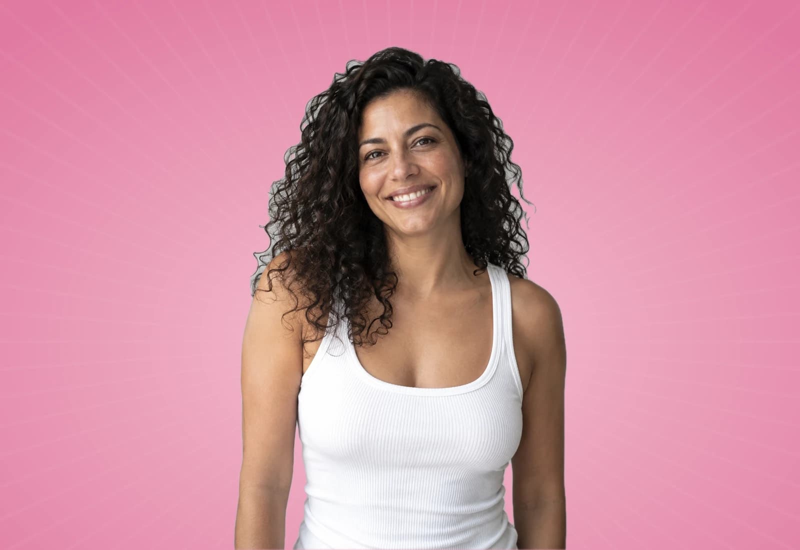 Smiling woman with curly hair on a rose background