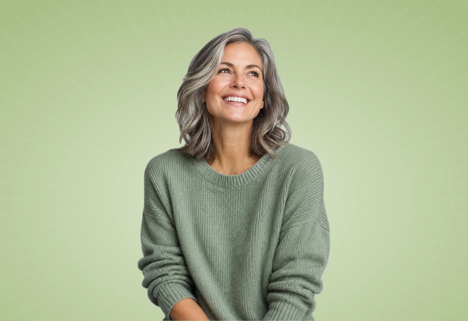 Smiling woman with silver hair on a sage background